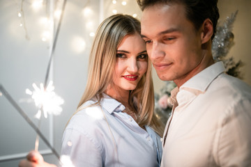 A guy with a girl is celebrating Christmas. A loving couple enjoy each other on New Year's Eve. New Year's love story