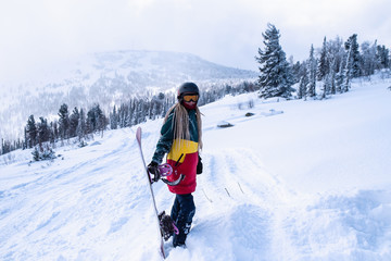 Snowboarder freerider woman on a snowy slope in Siberian mountains.