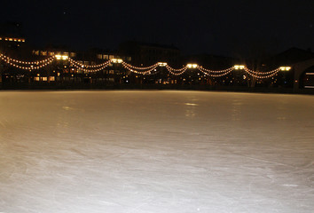 Fototapeta premium Ice rink illuminated by garland at night, ice.
