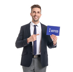 Businessman holding paper with text I VOTED on white background