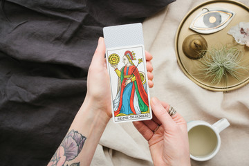 Girls with tarot cards in hands and cup of tea.