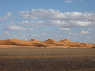 Fototapeta na wymiar Sahara Sand Dunes with blue sky and clouds - physical geography light and shadow -Morocco Inshallah