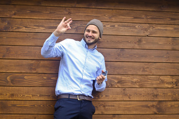 Portrait of a handsome man in a shirt on a wooden wall background. Businessman, boss in stylish clothes. Stock Photo for design