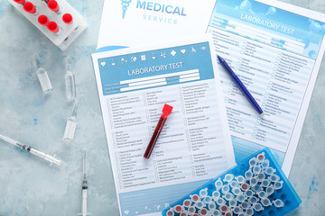 Laboratory test forms and blood samples on table