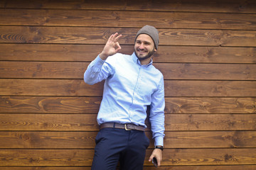 Portrait of a handsome man in a shirt on a wooden wall background. Businessman, boss in stylish clothes. Stock Photo for design