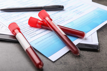 Laboratory test form and blood samples on table