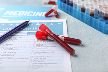 Laboratory test form and blood samples on table