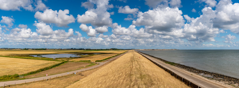 Landscape of the Netherlands, Dyke on the island of Texel suffer during extreme drought. Typical polder landscape with 'Dutch' clouds and Wadden Sea. Flood control.