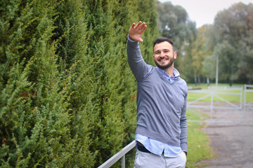 Young guy on the background of European, American city. man in the background of trees and fields and fence. The owner of a beautiful land for business