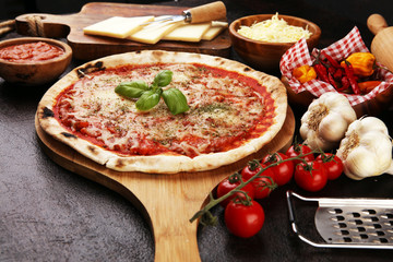 Pizza with tomatoes, mozzarella cheese, basil. Delicious italian pizza on wooden pizza board.