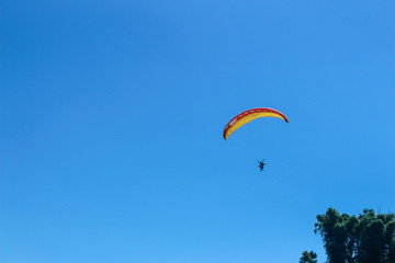 a paraglider flying in blue sky landscape in Indonesia