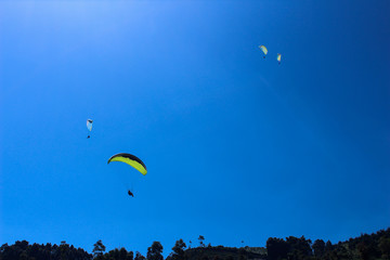 a paraglider flying in blue sky landscape in Indonesia