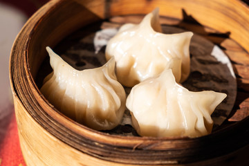 Close up fresh steamed chinese dumplings on bamboo basket.