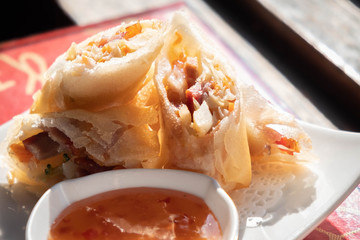 Fried chinese spring rolls with sweet chili sauce.