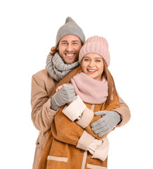 Happy couple in winter clothes on white background