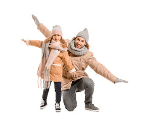 Handsome man and his little daughter in winter clothes on white background