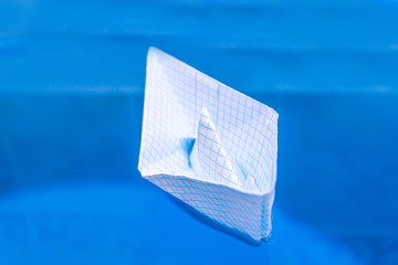 checkered paper boat in blue water