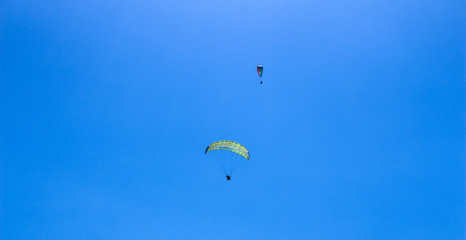 a paraglider flying in blue sky landscape in Indonesia