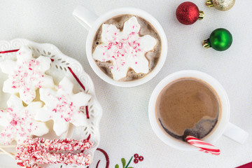 Mugs of hot chocolate and variety of toppings for hot chocolate.