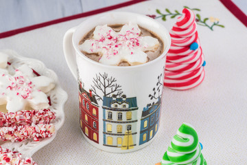 Mugs of hot chocolate and variety of toppings for hot chocolate.