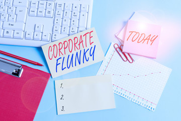 Text sign showing Corporate Flunky. Business photo showcasing someone who works obediently for another demonstrating in company Paper blue desk computer keyboard office study notebook chart numbers