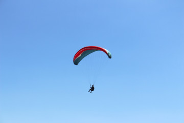 a paraglider flying in blue sky landscape in Indonesia