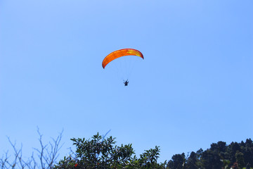 a paraglider flying in blue sky landscape in Indonesia