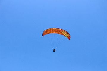 a paraglider flying in blue sky landscape in Indonesia