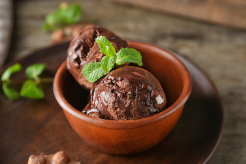 Bowl with tasty chocolate ice-cream on table