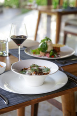 Beautifully decorated meals and a glasseof red wine on the wooden table