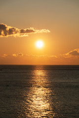Bright sunset with large yellow sun under the sea surface.