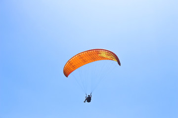 a paraglider flying in blue sky landscape in Indonesia