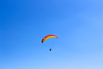 paraglider flying in blue sky on valleys landscape in Indonesia