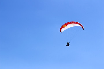 Fototapeta na wymiar paraglider flying in blue sky on valleys landscape in Indonesia