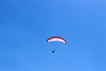 a paraglider flying in blue sky landscape in Indonesia