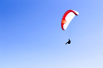 a paraglider flying in blue sky landscape in Indonesia