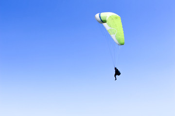 paraglider flying in blue sky on valleys landscape in Indonesia