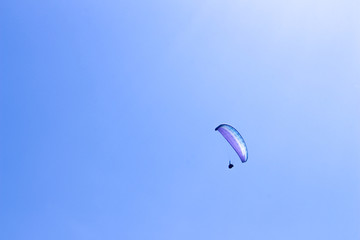 paraglider flying in blue sky on valleys landscape in Indonesia