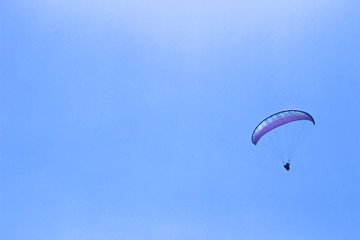 paraglider flying in blue sky on valleys landscape in Indonesia