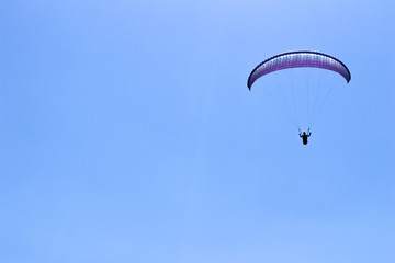 paraglider flying in blue sky on valleys landscape in Indonesia