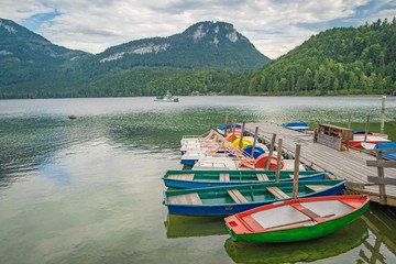 Fototapeta na wymiar boats on a mountain lake ready to lend tourists for swimming on the blue water surface