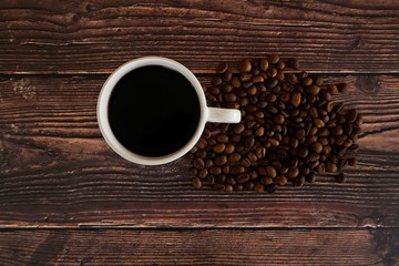 cup of coffee and beans on wooden table
