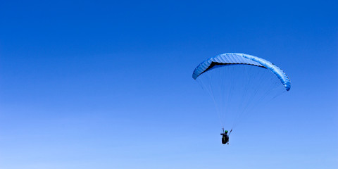 paraglider flying in blue sky on valleys landscape in Indonesia