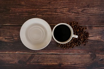 cup of coffee and beans on wooden table
