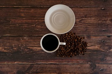 cup of coffee and beans on wooden table