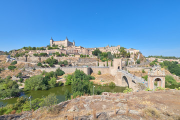 Fototapeta na wymiar Landscape view of the old town of the medieval city of Toledo from above the Alcantara bridge over the Tagus river, Castilla la Mancha, Spain