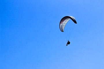 paraglider flying in blue sky on valleys landscape in Indonesia