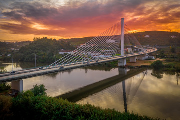 Cable-stayed bridge with semi-fan system steel structure Ponte Rainha Santa Isabel in Coimbra over the Mondego river during sunset