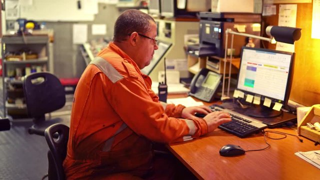 Marine engineer officer in engine control room ECR. Seamen's work. He works on the computer