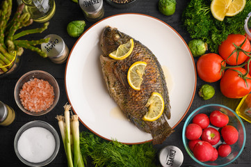 Grilled fish with fresh vegetables, on a wooden black background. I also eat healthy food. Seafood